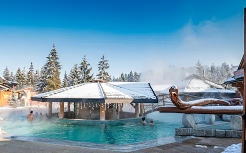 Gorący Potok Thermal Baths with snow-covered roofs and people enjoying the warm water in Poronin.
