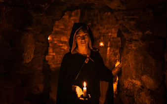 Guide holding candle in Edinburgh underground vaults on the Doomed, Dead and Buried tour.