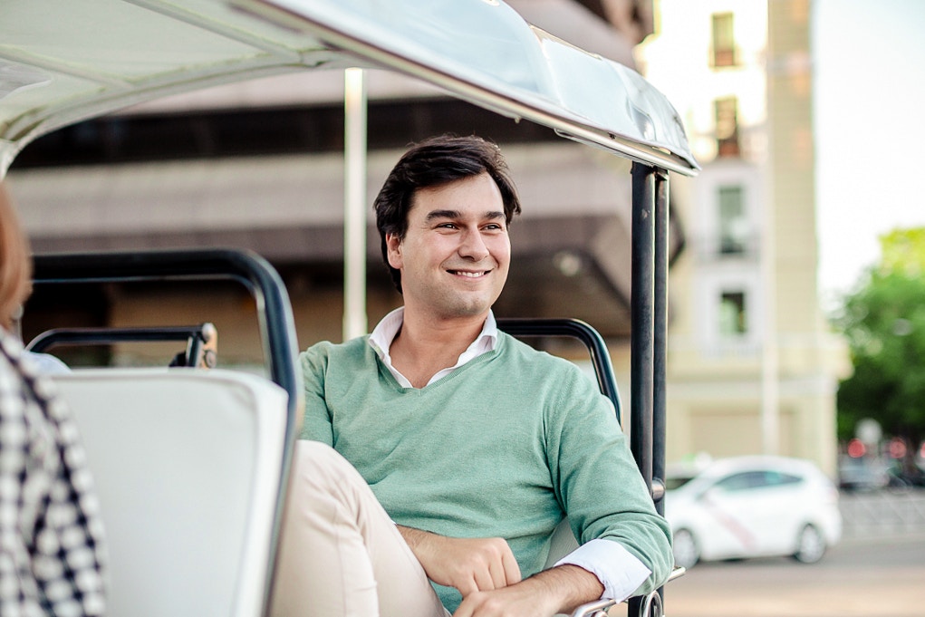 Man enjoying a ride in an Eco Tuk Tuk in a city setting.