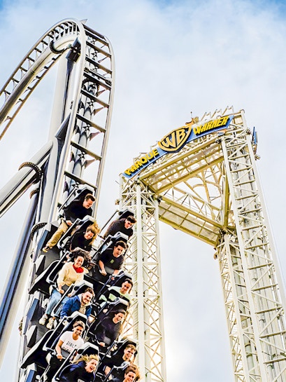 Parque Warner roller coaster with riders descending a steep drop.