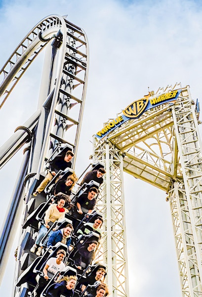 Parque Warner roller coaster with riders descending a steep drop.