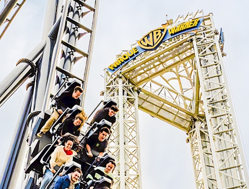 Parque Warner roller coaster with riders descending a steep drop.
