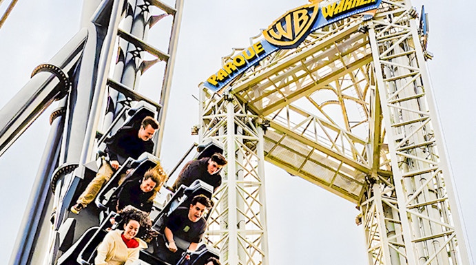 Parque Warner roller coaster with riders descending a steep drop.