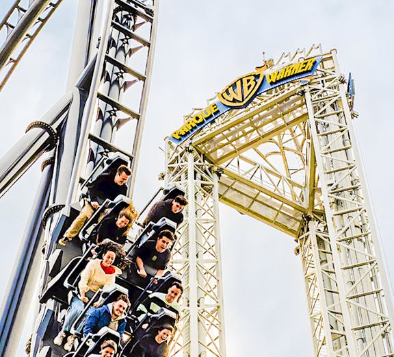Parque Warner roller coaster with riders descending a steep drop.