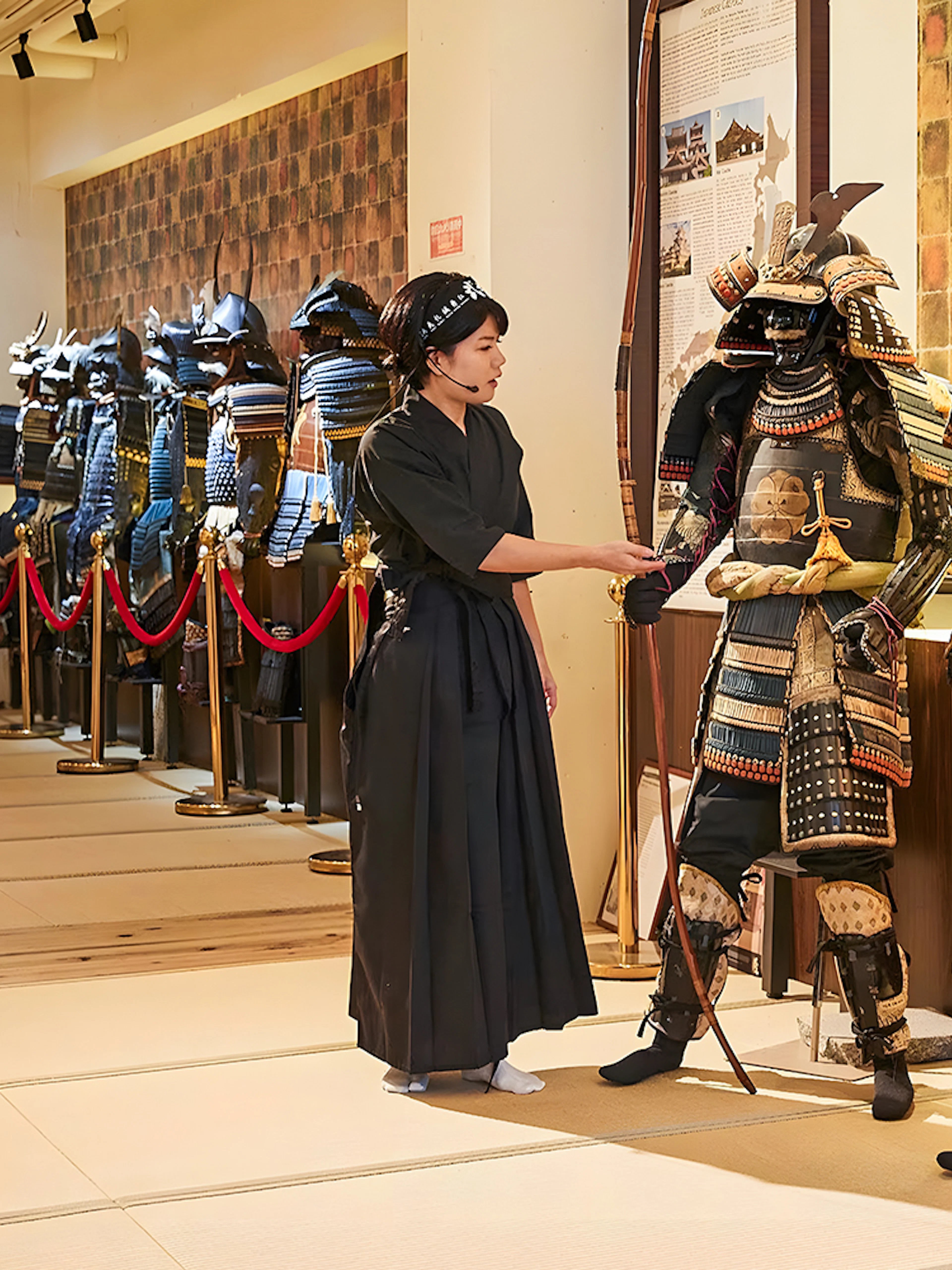 Tour guide explaining samurai armor to visitors at Samurai Ninja Museum Tokyo.