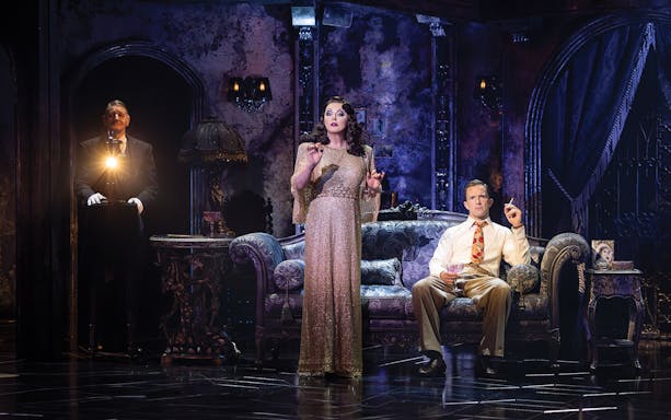 Actors performing a scene from Sunset Boulevard in an ornate living room set.