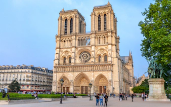 Notre Dame de Paris Cathedral facade with visitors in the foreground, France.