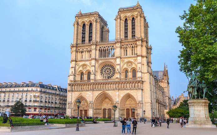 Notre Dame de Paris Cathedral facade with visitors in the foreground, France.