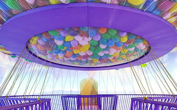 Colorful balloons suspended in a net at Bubble Planet An Experience Museum.