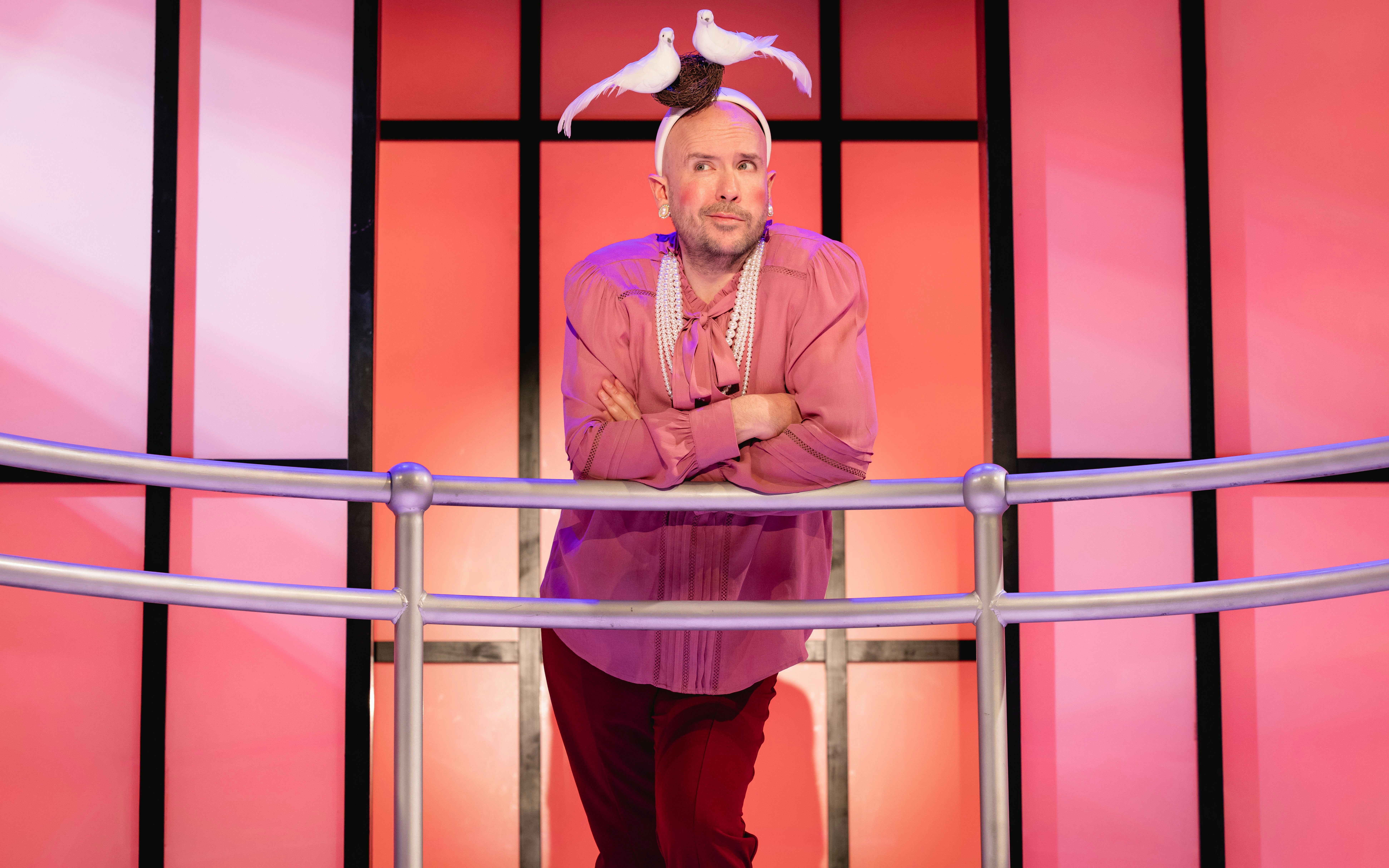 Stage performer in Titanique Westend with doves on headpiece.