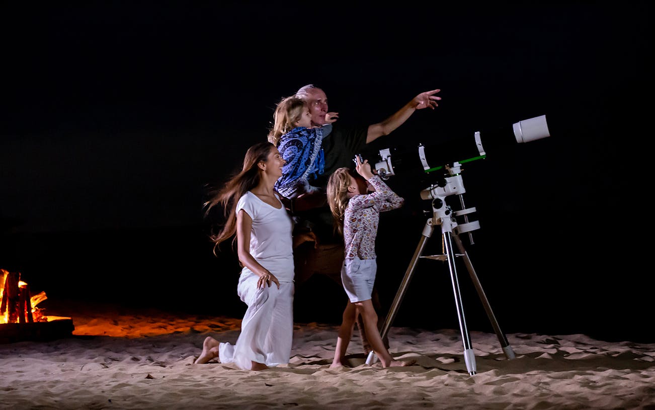 Family stargazing with telescope on Hurghada desert tour.