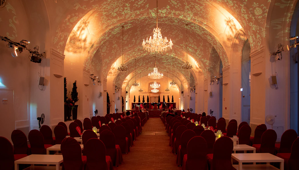 Elegant concert hall with chandeliers set for Blue Danube Waltz dinner and concert.