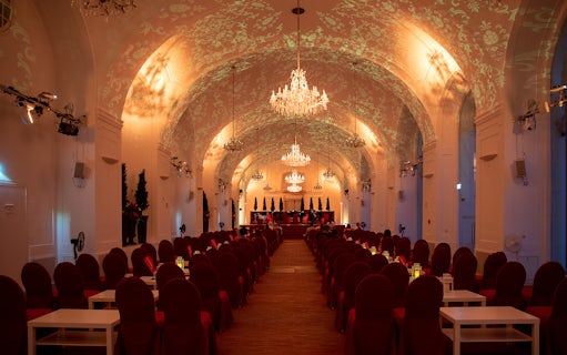 Elegant concert hall with chandeliers set for Blue Danube Waltz dinner and concert.