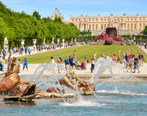 Palace of Versailles with musical fountain and garden view in France.