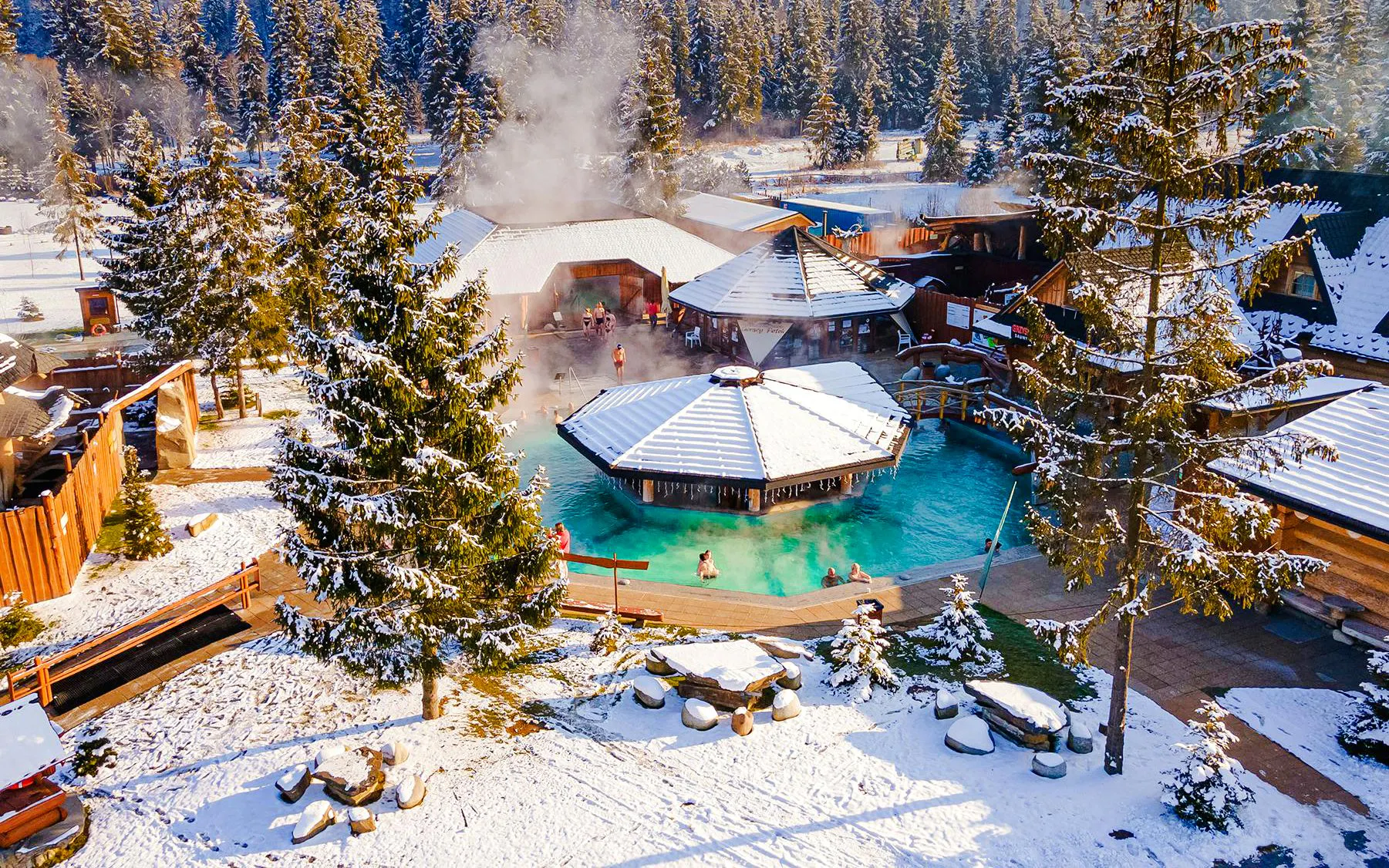 Guests bathing in Gorący Potok Thermal Baths, Zakopane, surrounded by snowy landscape.