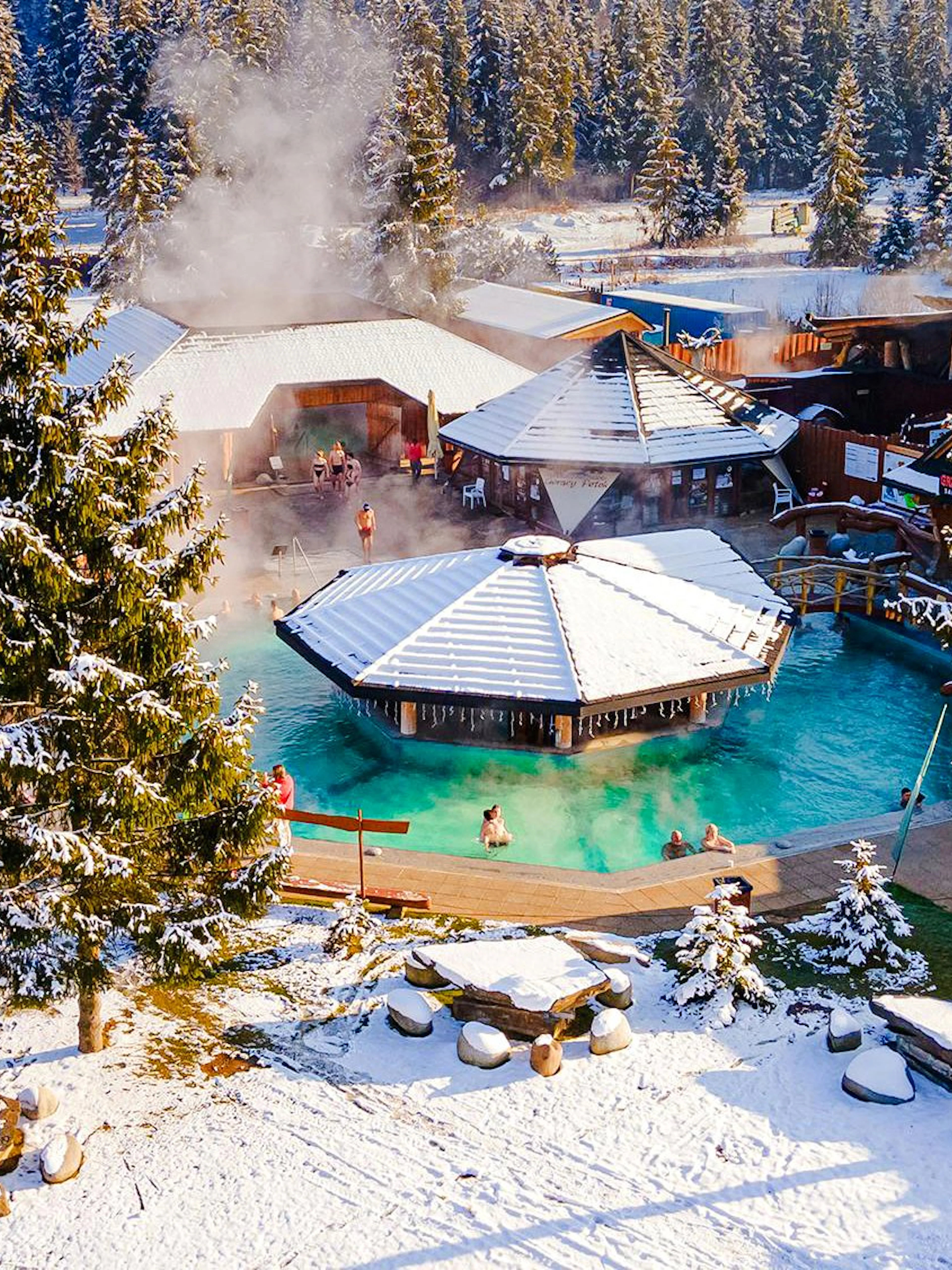 Guests bathing in Gorący Potok Thermal Baths, Zakopane, surrounded by snowy landscape.