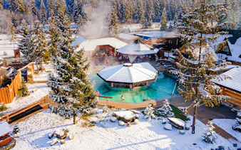 Guests bathing in Gorący Potok Thermal Baths, Zakopane, surrounded by snowy landscape.