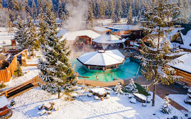 Guests bathing in Gorący Potok Thermal Baths, Zakopane, surrounded by snowy landscape.