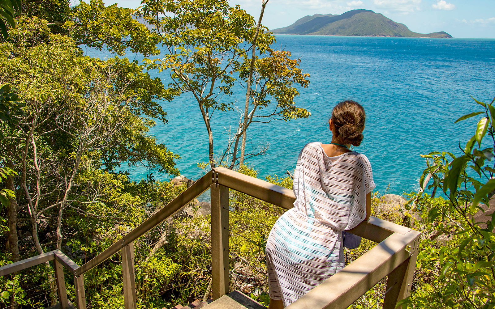 Woman overlooking the sea through a small lookout spot