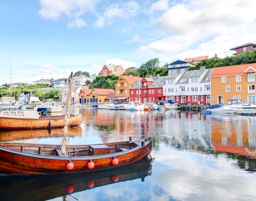 Boats docked with colorful wooden houses in the background, Haugesund.