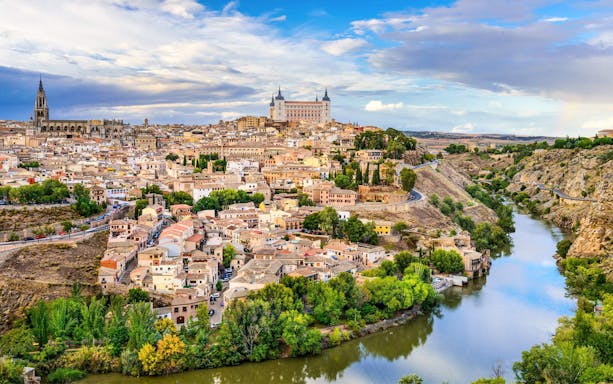 Toledo cityscape with Alcázar and Tagus River.