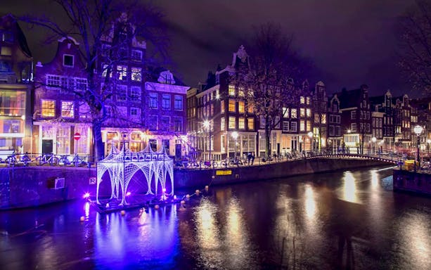 Amsterdam canal with illuminated art installation during Light Festival.