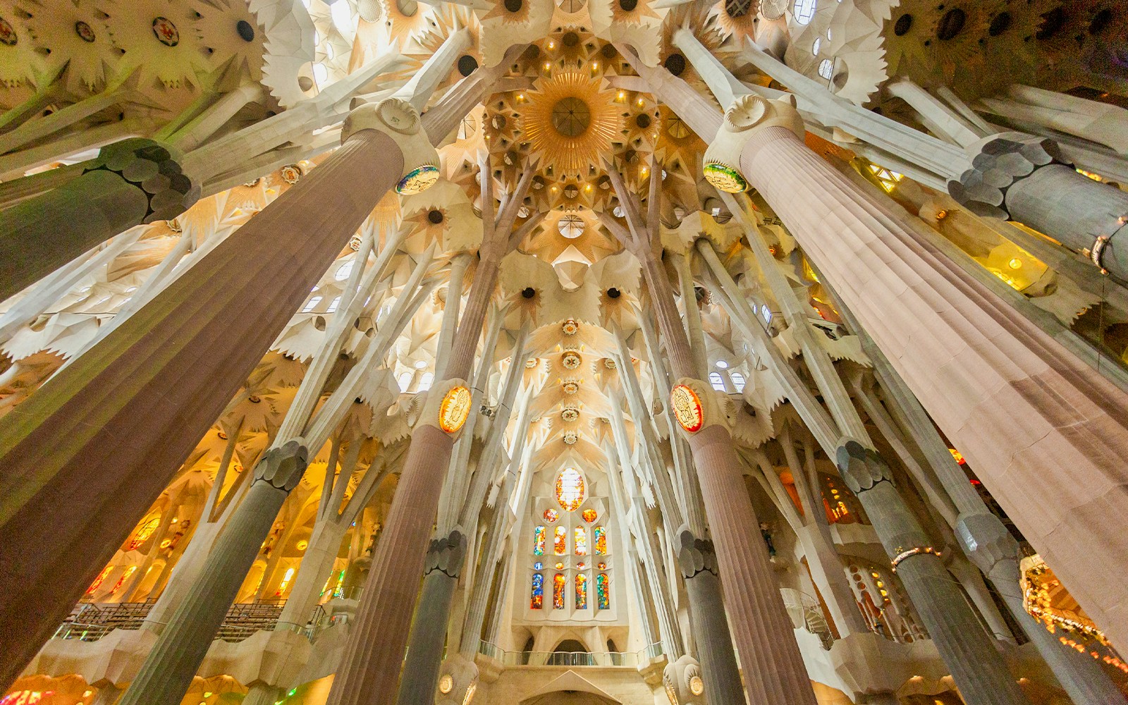 Interior view of Sagrada Familia's ornate ceiling and columns in Barcelona.