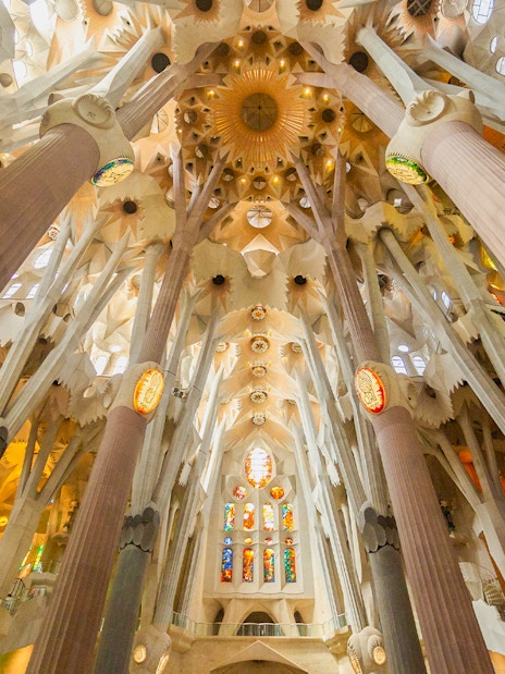 Interior view of Sagrada Familia's ornate ceiling and columns in Barcelona.