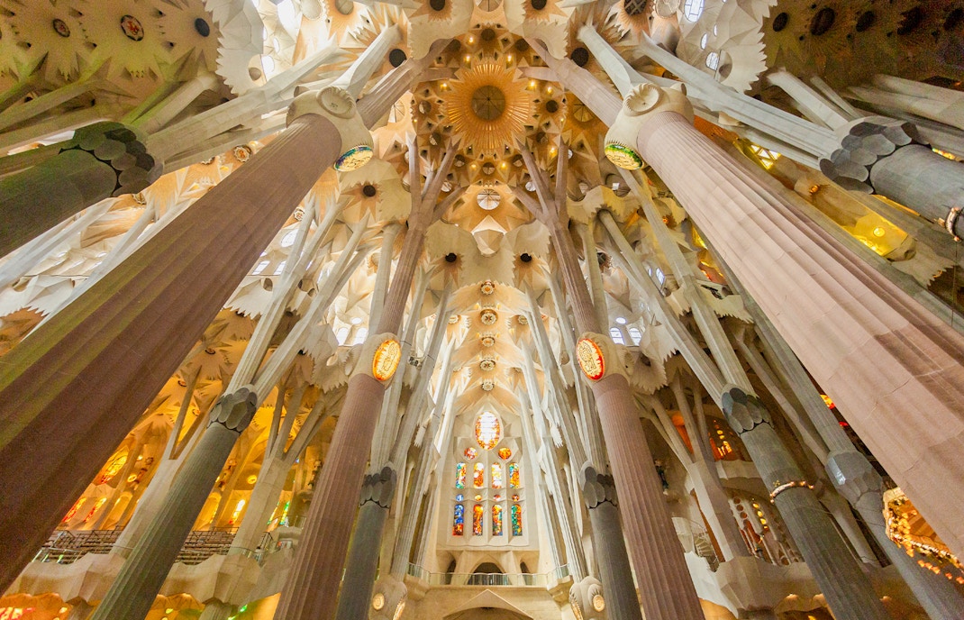 Interior view of Sagrada Familia's ornate ceiling and columns in Barcelona.