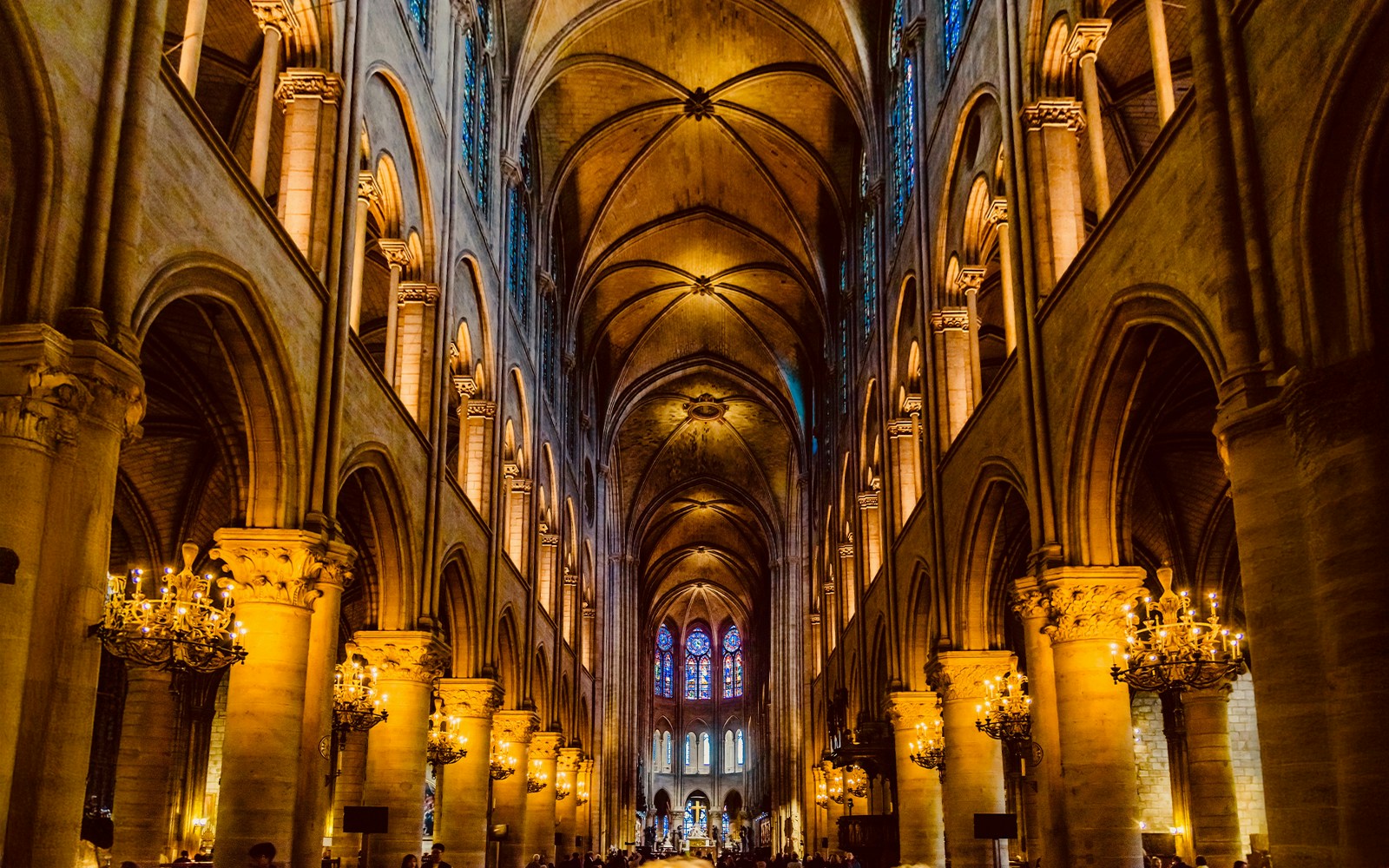 Notre Dame Cathedral interior with stained glass windows and vaulted ceilings, Paris, France.