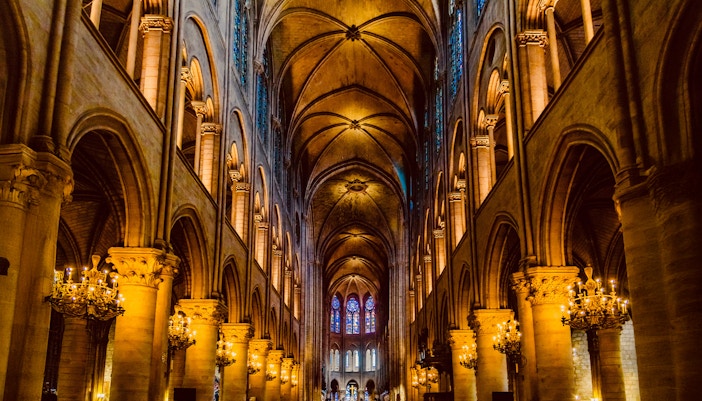 Notre Dame Cathedral interior with stained glass windows and vaulted ceilings, Paris, France.