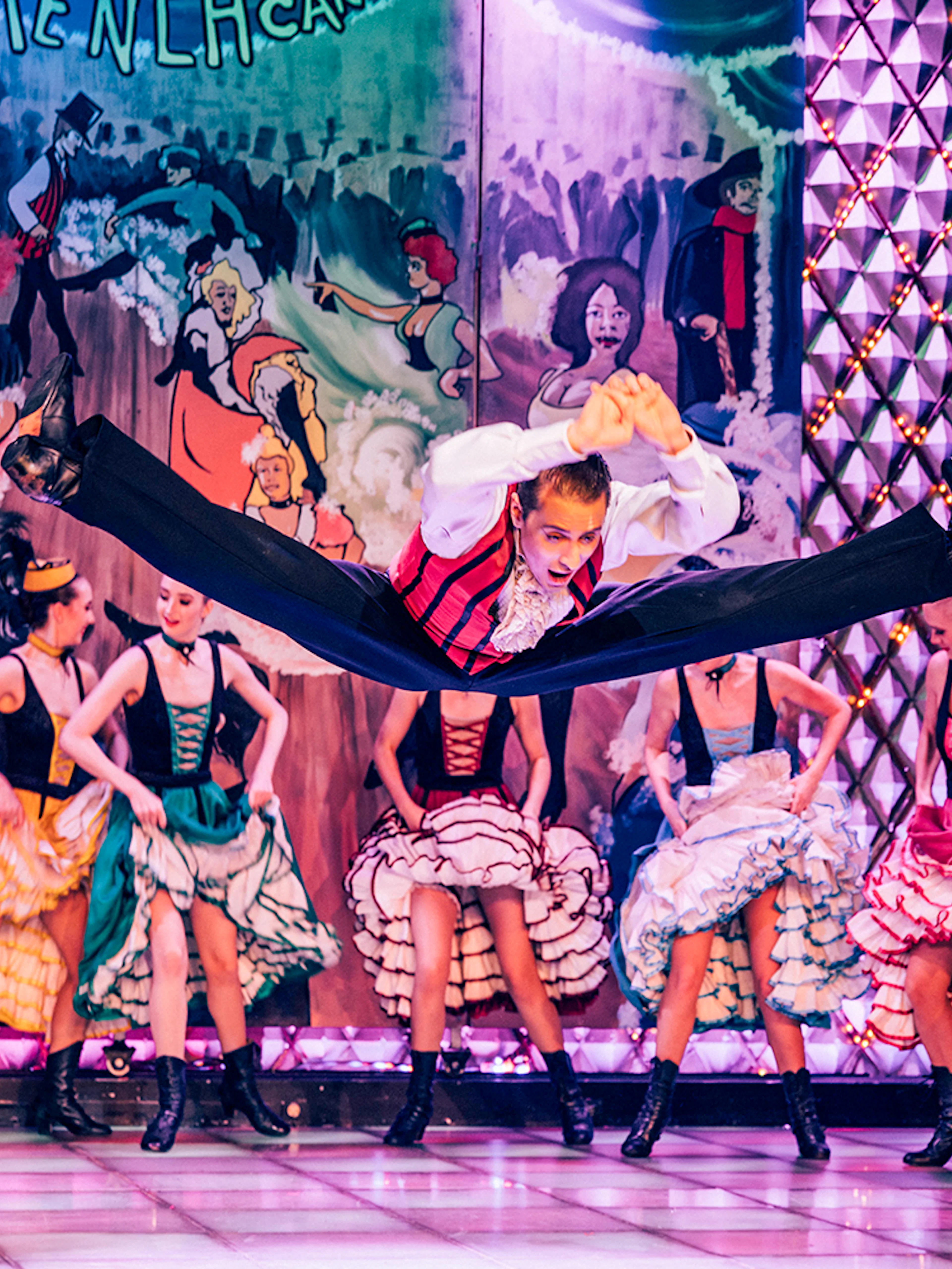 Dancers performing at Cabaret La Nouvelle Eve in Paris with vibrant costumes.