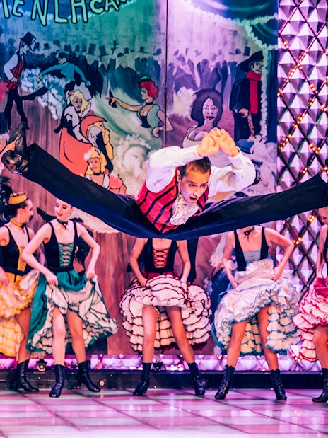 Dancers performing at Cabaret La Nouvelle Eve in Paris with vibrant costumes.