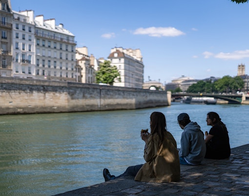 Les participants à une visite guidée se détendent près de la Seine