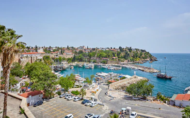 Antalya old town harbor with boats and historic buildings, sightseeing city tour.