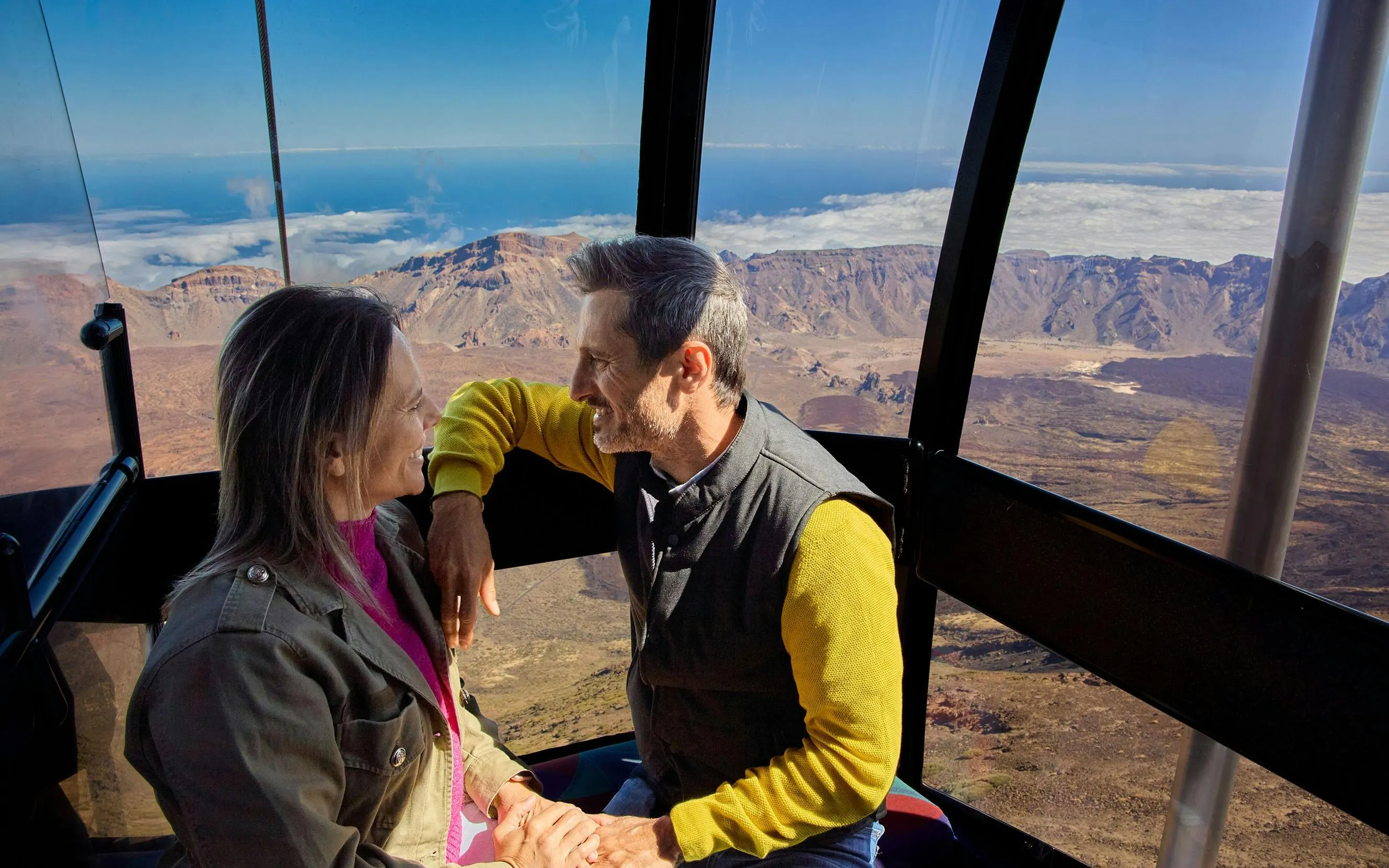 Guests enjoying Mount Teide cable car ride with scenic views of Tenerife landscape.
