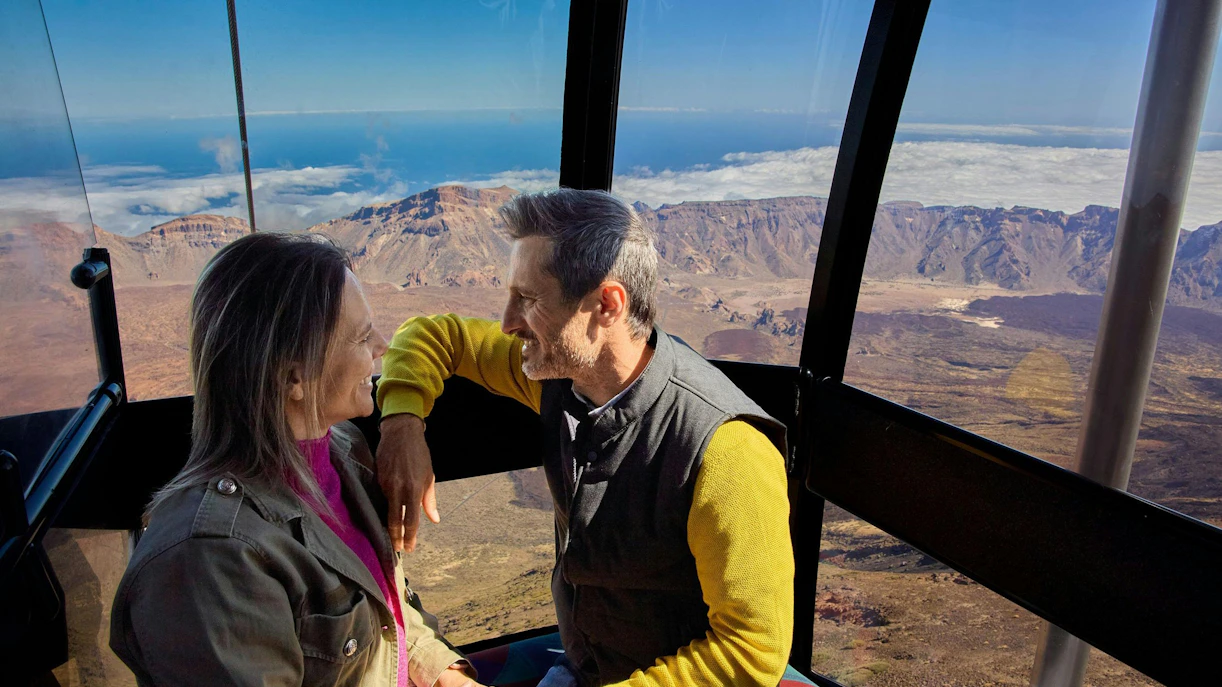 Guests enjoying Mount Teide cable car ride with scenic views of Tenerife landscape.