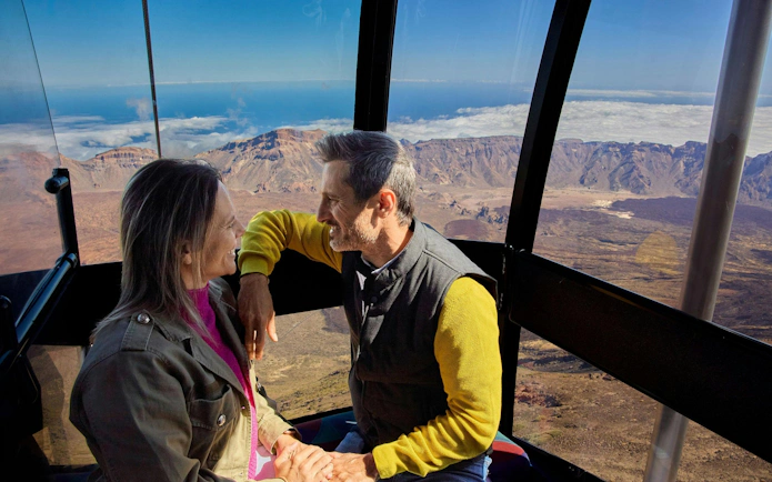 Guests enjoying Mount Teide cable car ride with scenic views of Tenerife landscape.