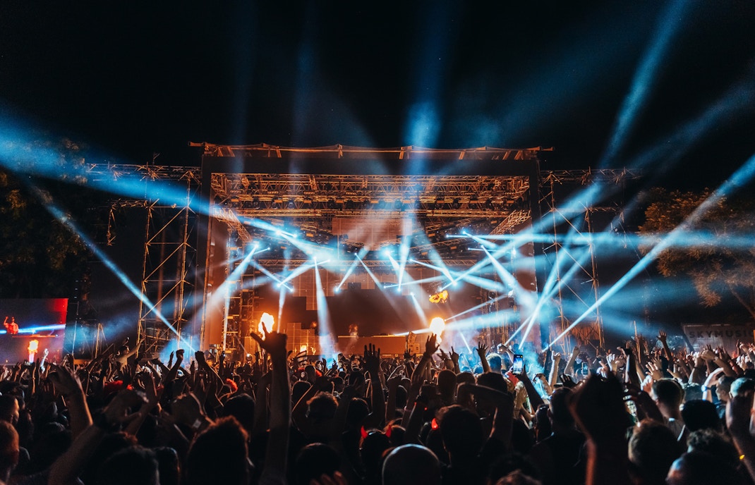 Crowd enjoying a live concert with bright stage lights at Prague music festival.