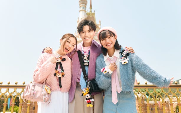 Three friends posing in front of Sleeping Beauty Castle at Disneyland Hong Kong.