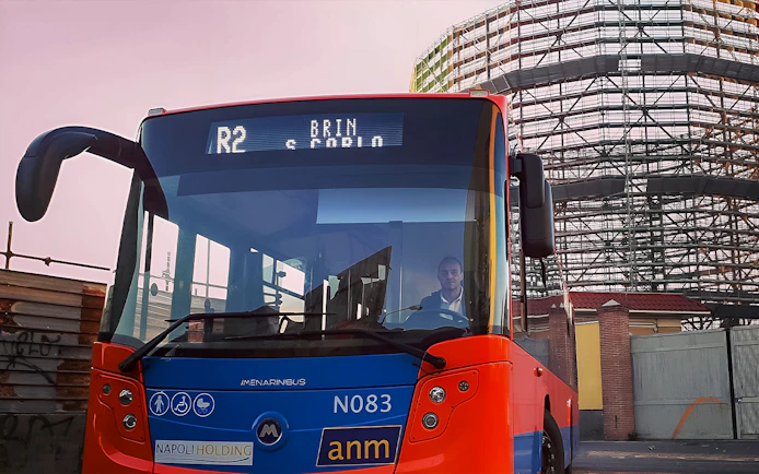 Naples city bus near construction site, offering round-trip tickets to/from Naples Airport.