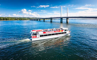 Sightseeing cruise boat near Kruununvuorensilta bridge, Finland.