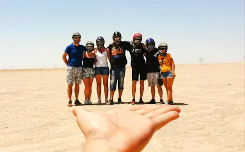 Group of people in helmets standing in the desert during Hurghada safari trip.