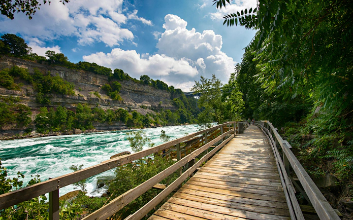 Wooden walkway beside white water rapids in Niagara Gorge.