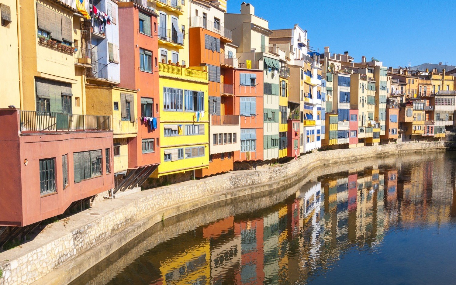Colorful houses reflecting in the Onyar River, Girona, Spain.