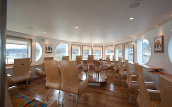 Interior of Lake Yamanaka Swan Lake cruise ship with wooden seating and large windows.
