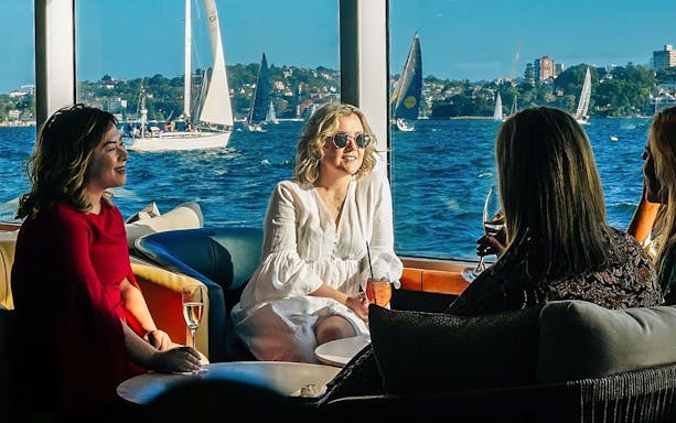 Guests enjoying drinks on a yacht during the Sydney to Hobart Yacht Race Lunch Cruise.