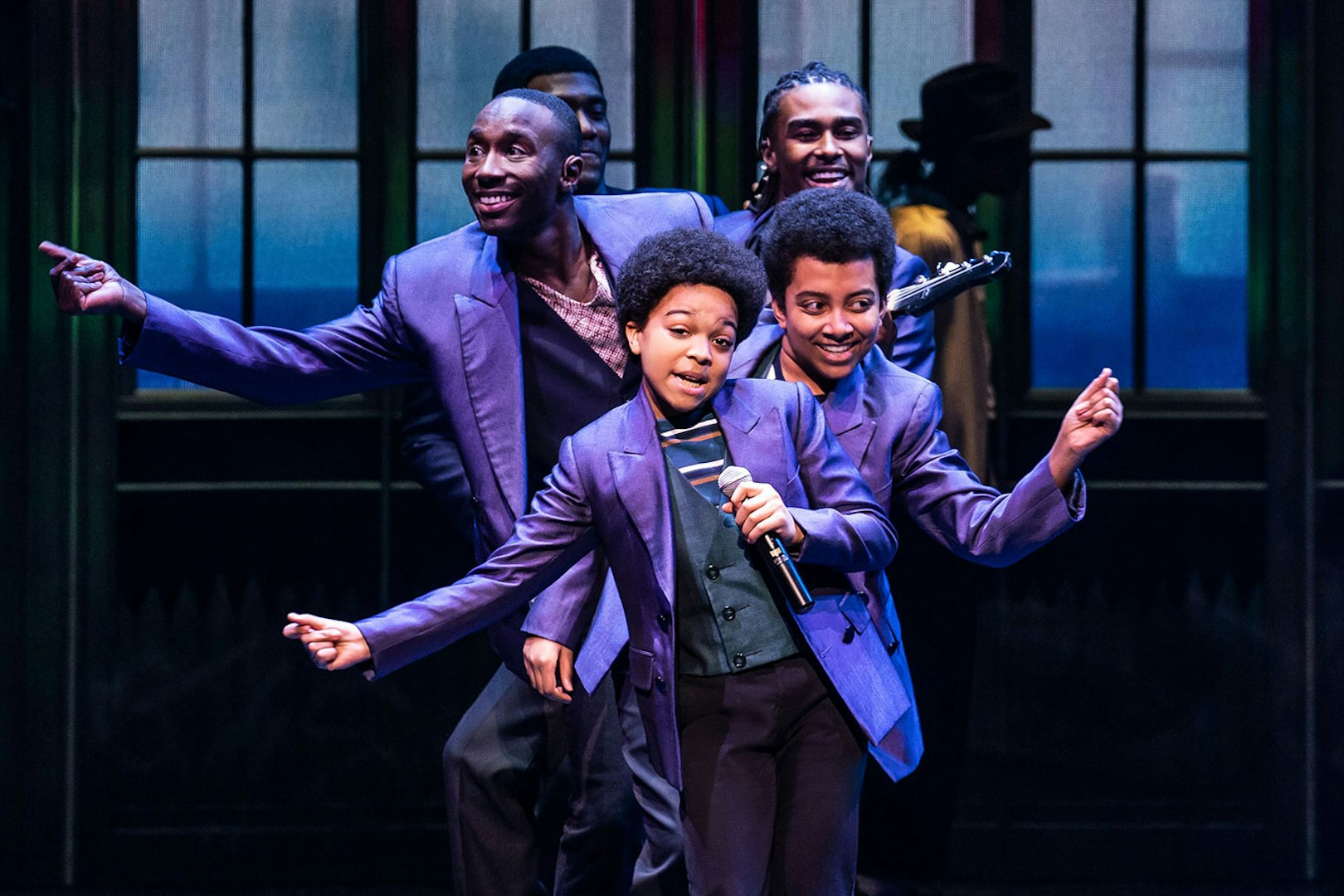 Performers in purple suits dancing on stage during MJ Das Musical.