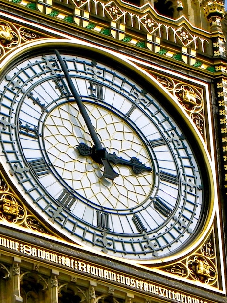 Close-up of Big Ben clock face in London, showing Roman numerals and ornate details.