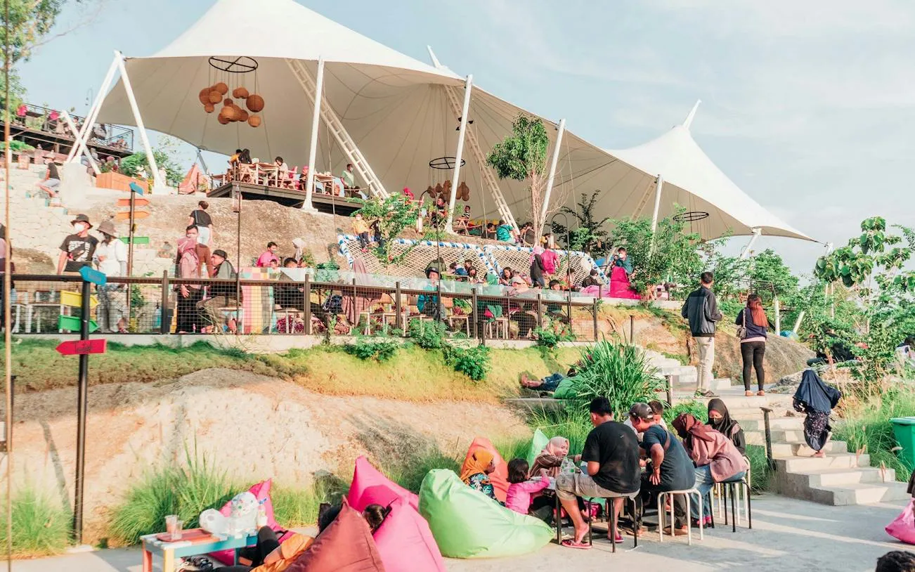 Outdoor seating area with people relaxing under a large canopy in Dubai.